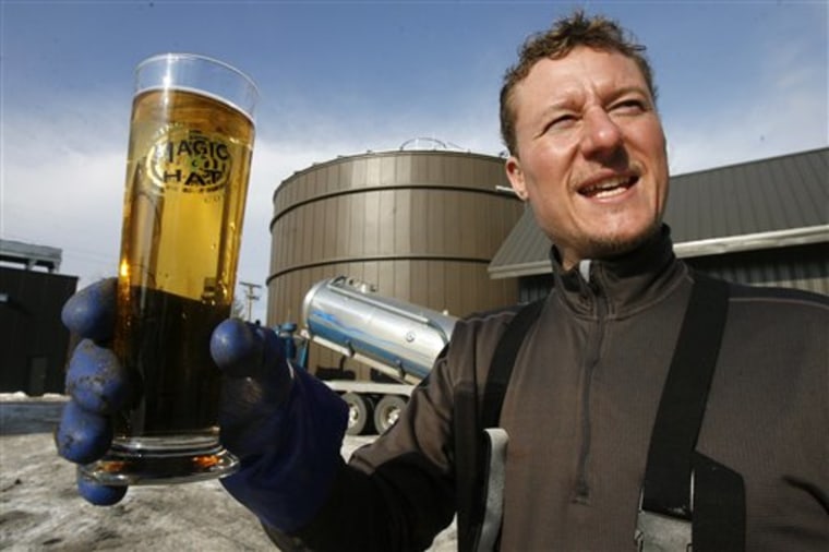 In this Jan. 26, 2011 photo, Eric Fitch holds a Magic Hat glass in front of the digester building at the brewery in South Burlington, Vt. 